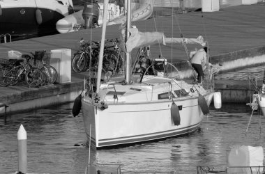 İtalya, Sicilya, Akdeniz, Marina di Ragusa (Ragusa ili); 2 Haziran 2023, limandaki bir yelkenli teknesinde insanlar - EDITORIAL