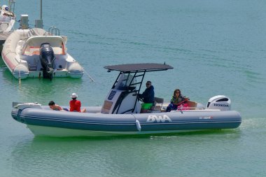 İtalya, Sicilya, Akdeniz, Marina di Ragusa (Ragusa Eyaleti); 3 Haziran 2023, limandaki kauçuk bir teknede insanlar - EDITORIAL