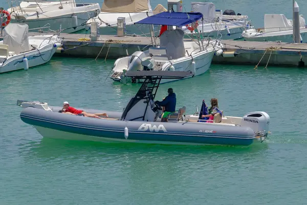 İtalya, Sicilya, Akdeniz, Marina di Ragusa (Ragusa Eyaleti); 3 Haziran 2023, limandaki kauçuk bir teknede insanlar - EDITORIAL