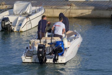 İtalya, Sicilya, Akdeniz, Marina di Ragusa (Ragusa Eyaleti); 3 Haziran 2023, limandaki bir motorlu teknede balıkçı - EDITORIAL