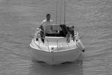 İtalya, Sicilya, Akdeniz, Marina di Ragusa (Ragusa Eyaleti); 4 Haziran 2023, limandaki bir motorlu teknede balıkçı - EDITORIAL