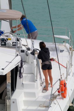 İtalya, Sicilya, Akdeniz, Marina di Ragusa (Ragusa ili); 4 Haziran 2023, limandaki bir yelkenli teknesinde insanlar - EDITORIAL