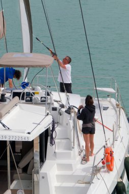 İtalya, Sicilya, Akdeniz, Marina di Ragusa (Ragusa ili); 4 Haziran 2023, limandaki bir yelkenli teknesinde insanlar - EDITORIAL