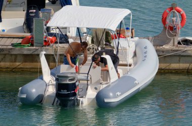 İtalya, Sicilya, Akdeniz, Marina di Ragusa (Ragusa ili); 9 Haziran 2023, limandaki kauçuk bir teknede adamlar - EDITORIAL