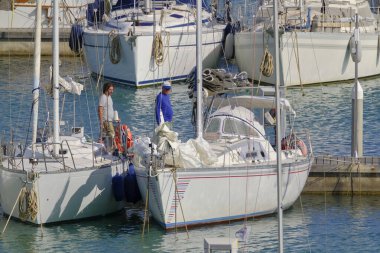 İtalya, Sicilya, Akdeniz, Marina di Ragusa (Ragusa Eyaleti); 11 Haziran 2023, limanda insanlar ve yelkenliler - EDITORIAL