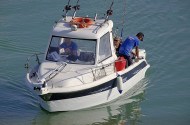 İtalya, Sicilya, Akdeniz, Marina di Ragusa (Ragusa Eyaleti); 20 Haziran 2023, limandaki bir motorlu teknede balıkçı - EDITORIAL