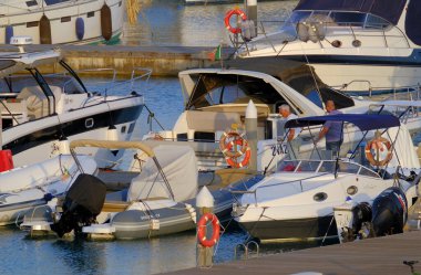 İtalya, Sicilya, Akdeniz, Marina di Ragusa (Ragusa Eyaleti); 20 Haziran 2023, gün batımında limanda halk, motorlu tekne ve lüks yatlar - EDITORIAL