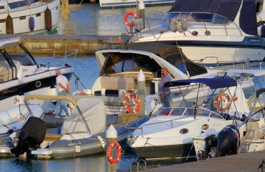 İtalya, Sicilya, Akdeniz, Marina di Ragusa (Ragusa Eyaleti); 20 Haziran 2023, gün batımında limanda halk, motorlu tekne ve lüks yatlar - EDITORIAL