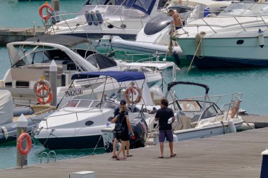 İtalya, Sicilya, Akdeniz, Marina di Ragusa (Ragusa Eyaleti); 24 Haziran 2023, limanda insanlar, motorlu tekneler ve lüks yatlar - EDITORIAL