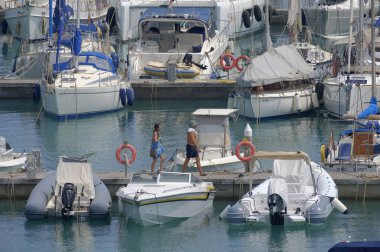 İtalya, Sicilya, Akdeniz, Marina di Ragusa (Ragusa ili); 30 Haziran 2023, limandaki insanlar, motorlu tekneler ve lüks yatlar - EDITORIAL