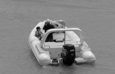 İtalya, Sicilya, Akdeniz, Marina di Ragusa (Ragusa Eyaleti); 1 Temmuz 2023, limandaki kauçuk bir teknede insanlar - EDITORIAL