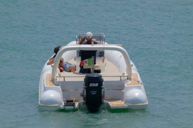 İtalya, Sicilya, Akdeniz, Marina di Ragusa (Ragusa Eyaleti); 1 Temmuz 2023, limandaki kauçuk bir teknede insanlar - EDITORIAL