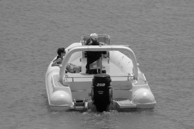 İtalya, Sicilya, Akdeniz, Marina di Ragusa (Ragusa Eyaleti); 1 Temmuz 2023, limandaki kauçuk bir teknede insanlar - EDITORIAL