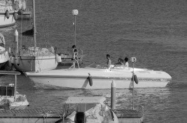 İtalya, Sicilya, Akdeniz, Marina di Ragusa (Ragusa Eyaleti); 3 Temmuz 2023, limanda lüks bir yatta insanlar - EDITORIAL