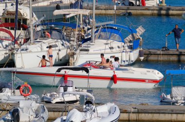 İtalya, Sicilya, Akdeniz, Marina di Ragusa (Ragusa Eyaleti); 3 Temmuz 2023, limanda lüks bir yatta insanlar - EDITORIAL