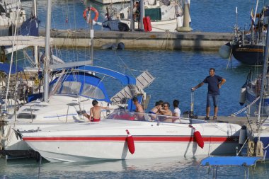 İtalya, Sicilya, Akdeniz, Marina di Ragusa (Ragusa Eyaleti); 3 Temmuz 2023, limanda lüks bir yatta insanlar - EDITORIAL