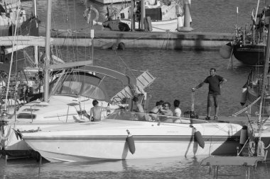 İtalya, Sicilya, Akdeniz, Marina di Ragusa (Ragusa Eyaleti); 3 Temmuz 2023, limanda lüks bir yatta insanlar - EDITORIAL