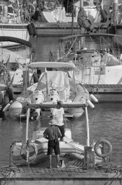 İtalya, Sicilya, Akdeniz, Marina di Ragusa (Ragusa Eyaleti); 5 Temmuz 2023, limandaki kauçuk bir teknede adam - EDITORIAL