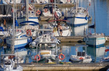 İtalya, Sicilya, Akdeniz, Marina di Ragusa (Ragusa ili); 6 Temmuz 2023, limandaki insanlar, motorlu tekneler ve lüks yatlar - EDITORIAL