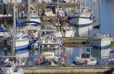 İtalya, Sicilya, Akdeniz, Marina di Ragusa (Ragusa ili); 6 Temmuz 2023, limandaki insanlar, motorlu tekneler ve lüks yatlar - EDITORIAL
