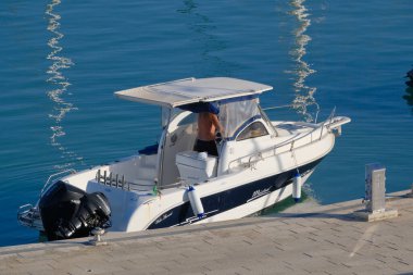 İtalya, Sicilya, Akdeniz, Marina di Ragusa (Ragusa Eyaleti); 6 Temmuz 2023, limandaki bir motorlu teknede adam - EDITORIAL