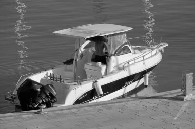 İtalya, Sicilya, Akdeniz, Marina di Ragusa (Ragusa Eyaleti); 6 Temmuz 2023, limandaki bir motorlu teknede adam - EDITORIAL