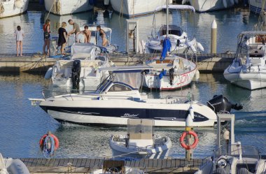 İtalya, Sicilya, Akdeniz, Marina di Ragusa (Ragusa Eyaleti); 6 Temmuz 2023, limandaki bir motorlu teknede adam - EDITORIAL