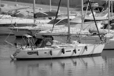 İtalya, Sicilya, Akdeniz, Marina di Ragusa (Ragusa Eyaleti); 7 Temmuz 2023, limandaki bir yelkenli ve lüks yatlarda erkekler - EDITORIAL