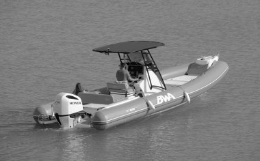 İtalya, Sicilya, Akdeniz, Marina di Ragusa (Ragusa ili); 7 Temmuz 2023, limandaki kauçuk bir teknede insanlar - EDITORIAL