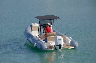 İtalya, Sicilya, Akdeniz, Marina di Ragusa (Ragusa ili); 7 Temmuz 2023, limandaki kauçuk bir teknede insanlar - EDITORIAL