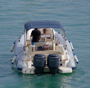 İtalya, Sicilya, Akdeniz, Marina di Ragusa (Ragusa ili); 8 Temmuz 2023, limanda büyük bir kauçuk teknede çift - EDITORIAL