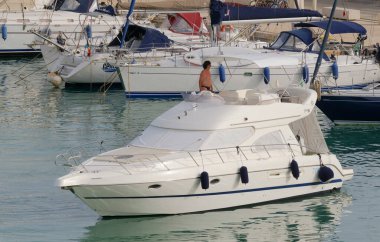 İtalya, Sicilya, Akdeniz, Marina di Ragusa (Ragusa Eyaleti); 8 Temmuz 2023, limanda lüks bir yatta adam - EDITORIAL