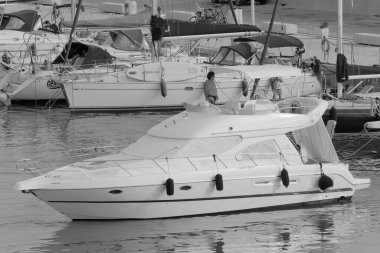 İtalya, Sicilya, Akdeniz, Marina di Ragusa (Ragusa Eyaleti); 8 Temmuz 2023, limanda lüks bir yatta adam - EDITORIAL