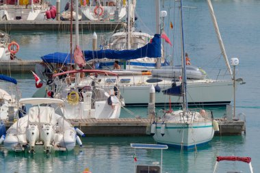 İtalya, Sicilya, Akdeniz, Marina di Ragusa (Ragusa ili); 9 Temmuz 2023, limandaki bir yelkenli teknesinde insanlar - EDITORIAL