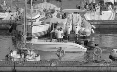 İtalya, Sicilya, Akdeniz, Marina di Ragusa (Ragusa Eyaleti); 9 Temmuz 2023, limandaki bir motorlu teknede balıkçı - EDITORIAL