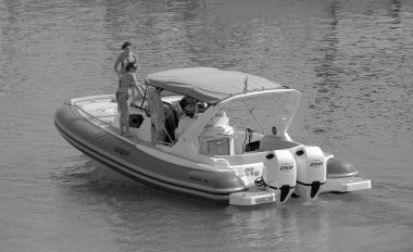 İtalya, Sicilya, Akdeniz, Marina di Ragusa (Ragusa Eyaleti); 9 Temmuz 2023, limandaki kauçuk bir teknede insanlar - EDITORIAL