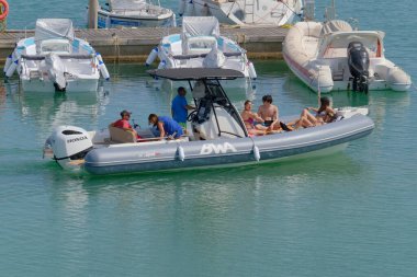 İtalya, Sicilya, Akdeniz, Marina di Ragusa (Ragusa Eyaleti); 10 Temmuz 2023, limandaki kauçuk bir teknede insanlar - EDITORIAL