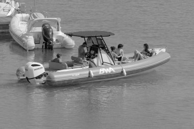 İtalya, Sicilya, Akdeniz, Marina di Ragusa (Ragusa Eyaleti); 10 Temmuz 2023, limandaki kauçuk bir teknede insanlar - EDITORIAL