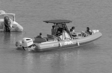 İtalya, Sicilya, Akdeniz, Marina di Ragusa (Ragusa Eyaleti); 10 Temmuz 2023, limandaki kauçuk bir teknede insanlar - EDITORIAL