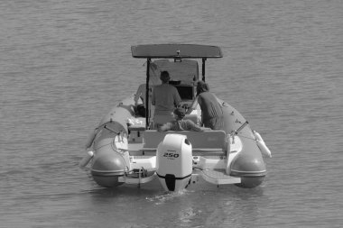 İtalya, Sicilya, Akdeniz, Marina di Ragusa (Ragusa Eyaleti); 10 Temmuz 2023, limandaki kauçuk bir teknede insanlar - EDITORIAL