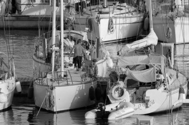 İtalya, Sicilya, Akdeniz, Marina di Ragusa (Ragusa Eyaleti); 20 Temmuz 2023, limandaki bir yelkenli teknesinde adam - EDITORIAL