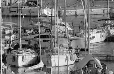 İtalya, Sicilya, Akdeniz, Marina di Ragusa (Ragusa ili); 21 Temmuz 2023, limandaki bir yelkenli teknesinde çift - EDITORIAL