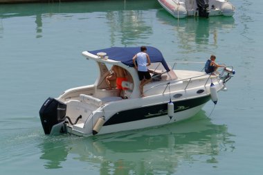 İtalya, Sicilya, Akdeniz, Marina di Ragusa (Ragusa Eyaleti); 29 Temmuz 2023, limanda lüks bir yatta köpeği olan insanlar - EDITORIAL