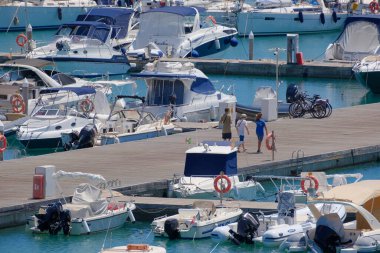 İtalya, Sicilya, Akdeniz, Marina di Ragusa (Ragusa ili); 2 Ağustos 2023, limandaki insanlar, motorlu tekneler ve lüks yatlar - EDITORIAL