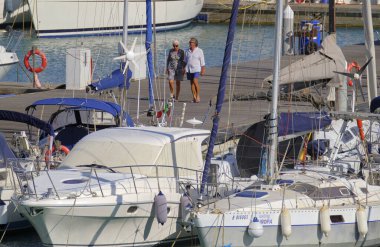 İtalya, Sicilya, Akdeniz, Marina di Ragusa (Ragusa ili); 2 Ağustos 2023, limanda insanlar ve lüks yatlar - EDITORIAL