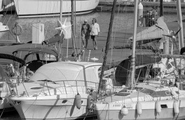 İtalya, Sicilya, Akdeniz, Marina di Ragusa (Ragusa ili); 2 Ağustos 2023, limanda insanlar ve lüks yatlar - EDITORIAL