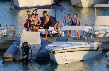 İtalya, Sicilya, Akdeniz, Marina di Ragusa (Ragusa ili); 2 Ağustos 2023, limandaki insanlar, motorlu tekneler ve lüks yatlar - EDITORIAL