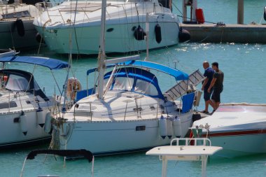 İtalya, Sicilya, Akdeniz, Marina di Ragusa (Ragusa ili); 6 Ağustos 2023, limandaki insanlar ve lüks yatlar - EDITORIAL