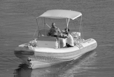 İtalya, Sicilya, Akdeniz, Marina di Ragusa (Ragusa ili); 13 Ağustos 2023, limandaki kauçuk bir teknede insanlar - EDITORIAL