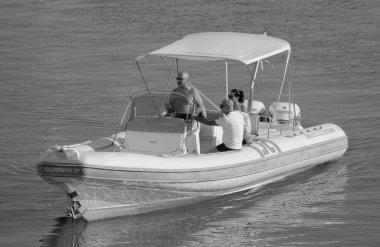 İtalya, Sicilya, Akdeniz, Marina di Ragusa (Ragusa ili); 13 Ağustos 2023, limandaki kauçuk bir teknede insanlar - EDITORIAL